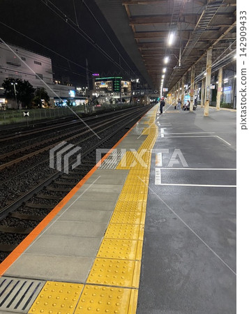 夜幕下的日本火車站月台和鐵軌,鋪設了黃色盲道磚,方便視障人士通行。 夜幕下的日本火車站月台和鐵軌,鋪設了黃色盲道磚,方便視障人士通行。 142909433