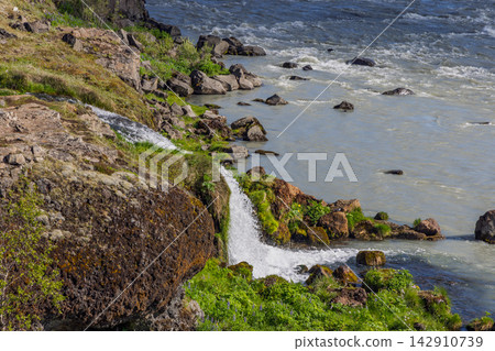 Urridafoss waterfall beside a large boulder and green riverbank, Thjorsa River, Iceland Urridafoss waterfall beside a large boulder and green riverbank, Thjorsa River, Iceland 142910739