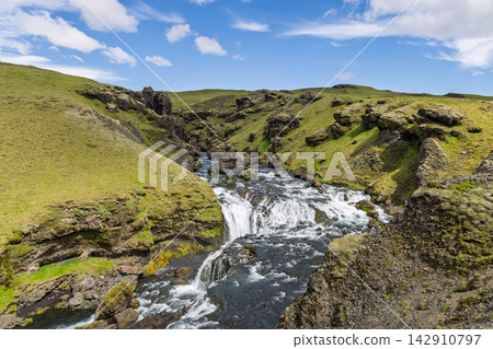 Fosstorfufoss cascades between grassy banks on the Skoga River in Iceland Fosstorfufoss cascades between grassy banks on the Skoga River in Iceland 142910797
