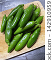 Freshly harvested green chili peppers 142910959