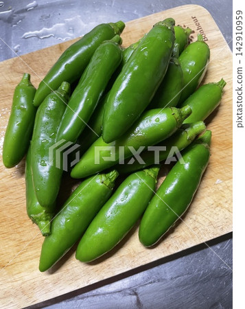 Freshly harvested green chili peppers Freshly harvested green chili peppers 142910959
