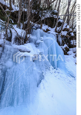 壯麗的藍色瀑布冰瀑和白雪皚皚的景色在寂靜的冬日群山中傲然屹立。 142911487