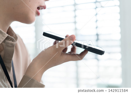 Young Businesswoman Working at Office Desk While Managing Documents and Mobile Communication. Young Businesswoman Working at Office Desk While Managing Documents and Mobile Communication. 142911584