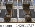 Weathered balconies and shuttered windows, Syros, Greece 142911787