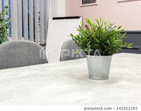 Decorative greenery rests on a minimalist office desk, enhancing the workspace with natural aesthetic details that foster calm focus and a professional mood for corporate meetings daily Decorative greenery rests on a minimalist office desk, enhancing the workspace with natural aesthetic details that foster calm focus and a professional mood for corporate meetings daily 142912165