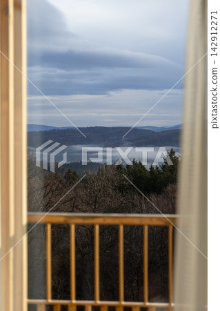 A serene foggy forest landscape viewed from a cozy indoor balcony, capturing the calm beauty of misty mountains and wild evergreen trees during a quiet and peaceful winter morning A serene foggy forest landscape viewed from a cozy indoor balcony, capturing the calm beauty of misty mountains and wild evergreen trees during a quiet and peaceful winter morning 142912271