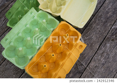 Bright paper packaging boxes for eggs on old vintage planks Easter background layout Bright paper packaging boxes for eggs on old vintage planks Easter background layout 142912346