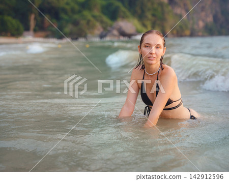 Young woman enjoying serene evening at sea in Krabi, Thailand Young woman enjoying serene evening at sea in Krabi, Thailand 142912596