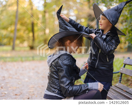 Mother and daughter preparing for Halloween walk in autumn park Mother and daughter preparing for Halloween walk in autumn park 142912605