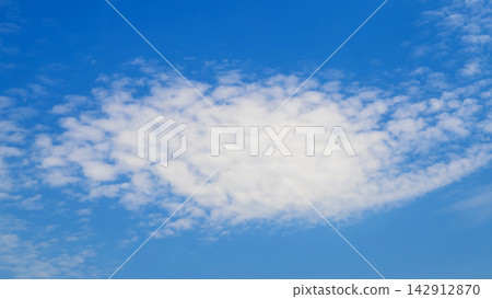 large oval white cloud set against a pure deep blue sky in clear weather large oval white cloud set against a pure deep blue sky in clear weather 142912870