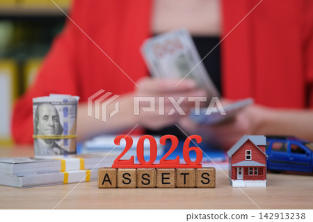 Counting assets and financial planning in 2026 with cash, a model house, and a toy car Counting assets and financial planning in 2026 with cash, a model house, and a toy car 142913238