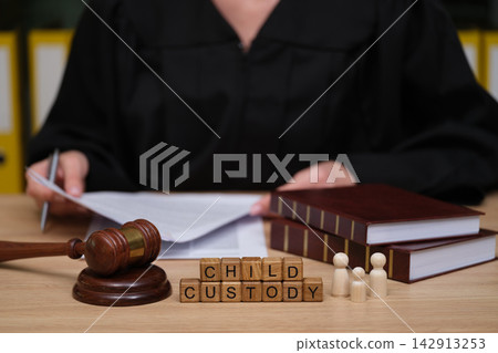 Judge presiding over a child custody case with documents and wooden gavel on the table Judge presiding over a child custody case with documents and wooden gavel on the table 142913253