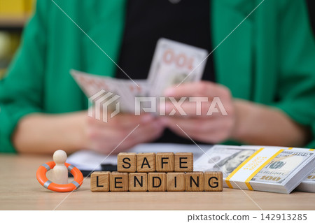Counting cash while promoting safe lending practices in a brightly lit office Counting cash while promoting safe lending practices in a brightly lit office 142913285