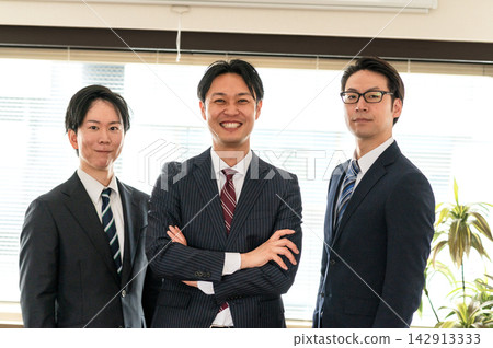 三個身穿西裝的男人雙手交叉放在胸前,看向鏡頭。 三個身穿西裝的男人雙手交叉放在胸前,看向鏡頭。 142913333