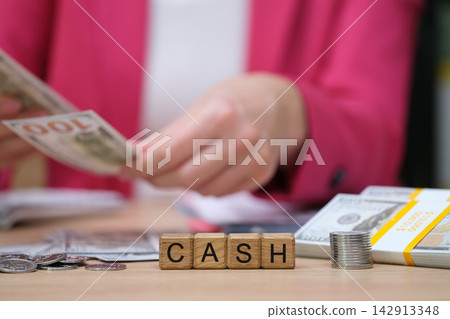 Counting cash in a busy office setting while managing finances and handling various currencies Counting cash in a busy office setting while managing finances and handling various currencies 142913348
