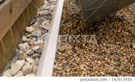 Pouring gravel for garden landscaping and home improvement Pouring gravel for garden landscaping and home improvement 142913450