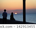 A couple watching the sunset over the sea. 142913455