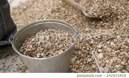 Close up of a metal bucket full of gravel for construction or landscaping Close up of a metal bucket full of gravel for construction or landscaping 142913458