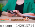 Support blocks amidst a busy workspace with a person engaged on their phone 142913714