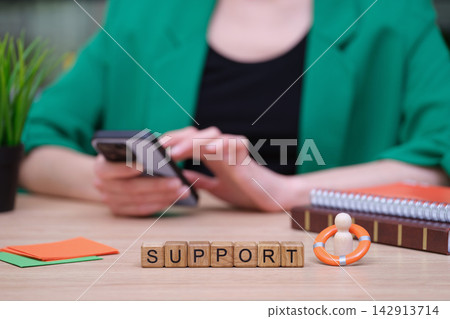Support blocks amidst a busy workspace with a person engaged on their phone Support blocks amidst a busy workspace with a person engaged on their phone 142913714
