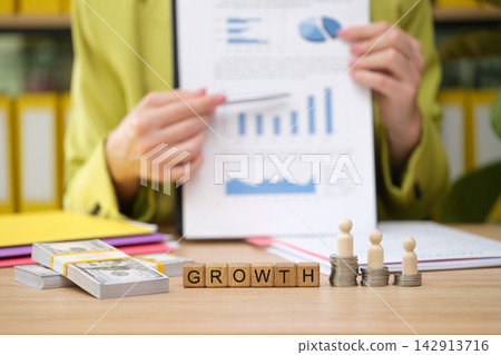 Examining financial growth through charts and strategies in a modern office environment Examining financial growth through charts and strategies in a modern office environment 142913716