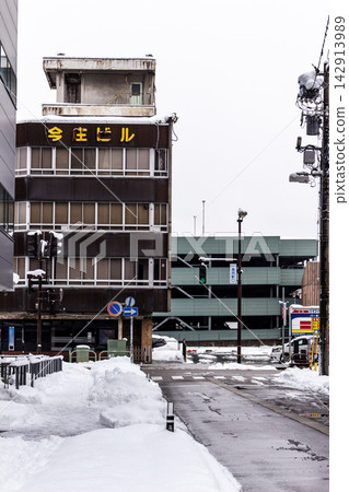 A low-angle view of a retro mixed-use building and intersection in a snow-covered provincial city hit by a severe cold wave. A low-angle view of a retro mixed-use building and intersection in a snow-covered provincial city hit by a severe cold wave. 142913989
