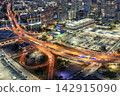 Aerial view of downtown Tampa at night with illuminated highway and flowing traffic highlighting urban growth and transportation infrastructure. 142915090