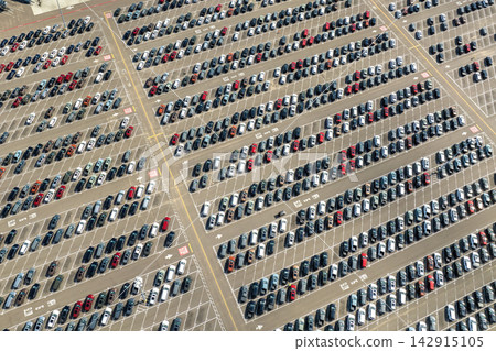 New cars stock at production factory parking lot. Vehicles parked in a row at dealer port terminal. Automotive industry. Import or export of new cars at warehouse New cars stock at production factory parking lot. Vehicles parked in a row at dealer port terminal. Automotive industry. Import or export of new cars at warehouse 142915105