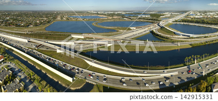 Aerial view of american highway junction with fast driving vehicles in Miami, Florida. View from above of USA transportation infrastructure 142915331