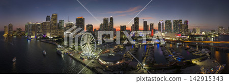American urban landscape at night. Miami marina and Skyviews Observation Wheel at Bayside Marketplace with reflections in Biscayne Bay water and skyscrapers of Brickell, city's financial center American urban landscape at night. Miami marina and Skyviews Observation Wheel at Bayside Marketplace with reflections in Biscayne Bay water and skyscrapers of Brickell, city's financial center 142915343