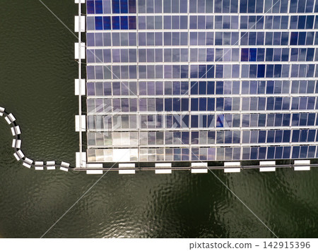 Solar photovoltaic panels floating on lake at sustainable energy facility. Clean electric power generation with zero emissions using water-based technology Solar photovoltaic panels floating on lake at sustainable energy facility. Clean electric power generation with zero emissions using water-based technology 142915396