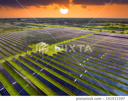 Aerial view of large sustainable electrical power plant with rows of solar photovoltaic panels for producing clean electric energy. Concept of renewable electricity with zero emission Aerial view of large sustainable electrical power plant with rows of solar photovoltaic panels for producing clean electric energy. Concept of renewable electricity with zero emission 142915397