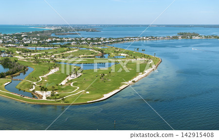 Aerial view of large golf field with green grass in Boca Grande, small town on Gasparilla Island in southwest Florida. Outdoor activities for wealthy people Aerial view of large golf field with green grass in Boca Grande, small town on Gasparilla Island in southwest Florida. Outdoor activities for wealthy people 142915408