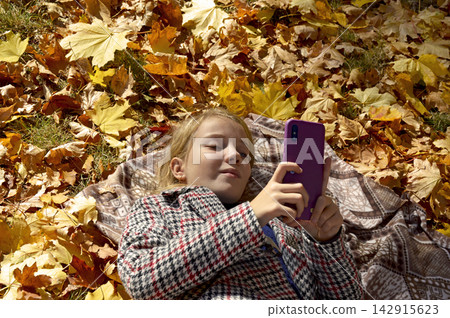 beautiful girl lies on the leaves in the autumn park 142915623