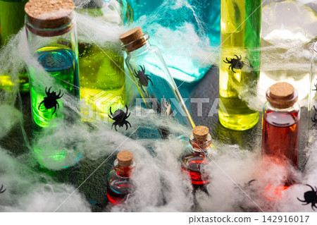 Halloween potion bottles with spiders and cobwebs for spooky party decoration or costume theme Halloween potion bottles with spiders and cobwebs for spooky party decoration or costume theme 142916017