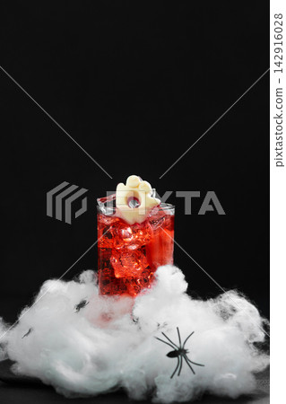 Spooky Halloween cocktail with ice and ghost decoration on cobweb Spooky Halloween cocktail with ice and ghost decoration on cobweb 142916028