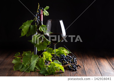 Elegant Red Wine Bottle And Glass With Fresh Grapes And Leaves On Wooden Table Elegant Red Wine Bottle And Glass With Fresh Grapes And Leaves On Wooden Table 142916041