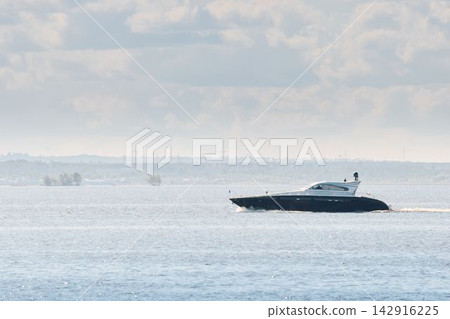 motorboat on horizon, magic reflections on water surface, sailing regatta in the Gulf of Finland at sunny day, Yachtsmen are sitting amicably on board of the sailing boat, teamwork motorboat on horizon, magic reflections on water surface, sailing regatta in the Gulf of Finland at sunny day, Yachtsmen are sitting amicably on board of the sailing boat, teamwork 142916225