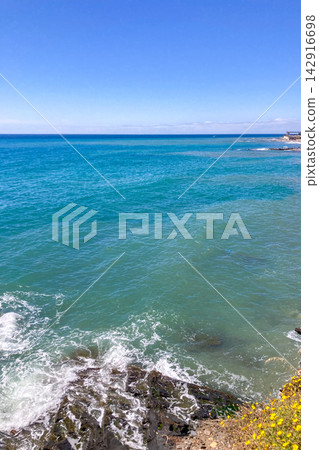 Blue calm sea stretches alongside the promenade creating relaxing coastal scenery with gentle reflections and peaceful Mediterranean atmosphere in Fuengirola, Spain Blue calm sea stretches alongside the promenade creating relaxing coastal scenery with gentle reflections and peaceful Mediterranean atmosphere in Fuengirola, Spain 142916698