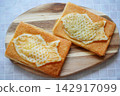 一種小吃，由金黃色的魚形鯛魚燒派組成，擺放在木盤上。 142917099