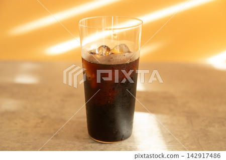 玻璃杯裡的黑咖啡;自然光線充足的桌子;以及冰咖啡。 玻璃杯裡的黑咖啡;自然光線充足的桌子;以及冰咖啡。 142917486