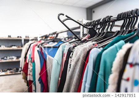 Secondhand clothing rack packed with assorted sweaters, jackets, and tops in thrift store Secondhand clothing rack packed with assorted sweaters, jackets, and tops in thrift store 142917851