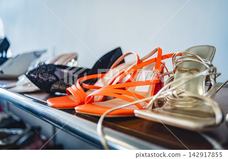 Row of women's sandals and heels on display in retail secondhand shop Row of women's sandals and heels on display in retail secondhand shop 142917855