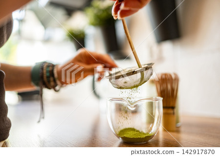 Girl Making Cold Matcha Green Tea in Kitchen Girl Making Cold Matcha Green Tea in Kitchen 142917870