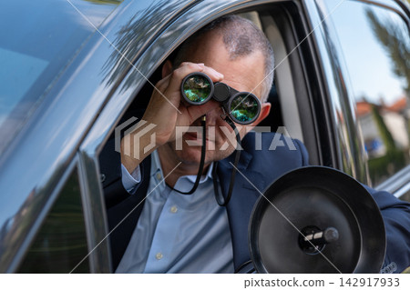 Spy conducting visual and acoustic surveillance from a car Spy conducting visual and acoustic surveillance from a car 142917933
