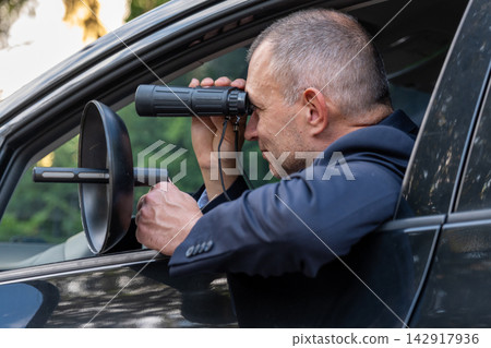 Special agent intercepting conversations with directional microphone during surveillance Special agent intercepting conversations with directional microphone during surveillance 142917936
