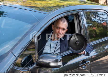 Security service officer with directional microphone inside a car Security service officer with directional microphone inside a car 142917941