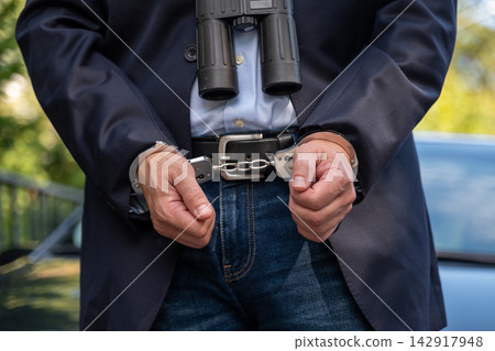Arrest of suspected spy with binoculars in close up Arrest of suspected spy with binoculars in close up 142917948