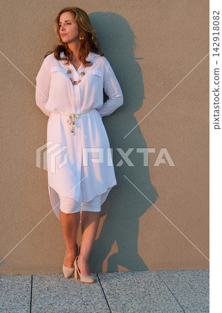 Confident Woman in White Dress Relaxing on Rooftop Balcony at Sunset With Sea View in Umag Confident Woman in White Dress Relaxing on Rooftop Balcony at Sunset With Sea View in Umag 142918082