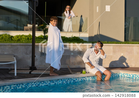 Family Morning By The Pool With Father And Son Enjoying Breakfast And Relaxation At Home Family Morning By The Pool With Father And Son Enjoying Breakfast And Relaxation At Home 142918088